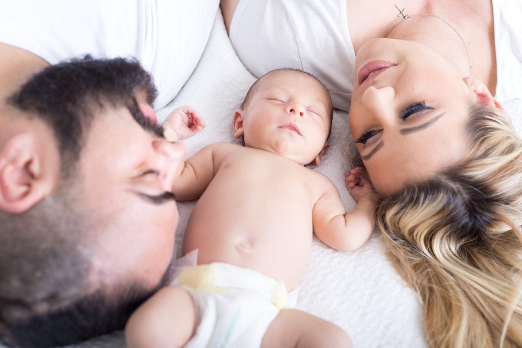 new mom and dad lay beside their newborn baby boy