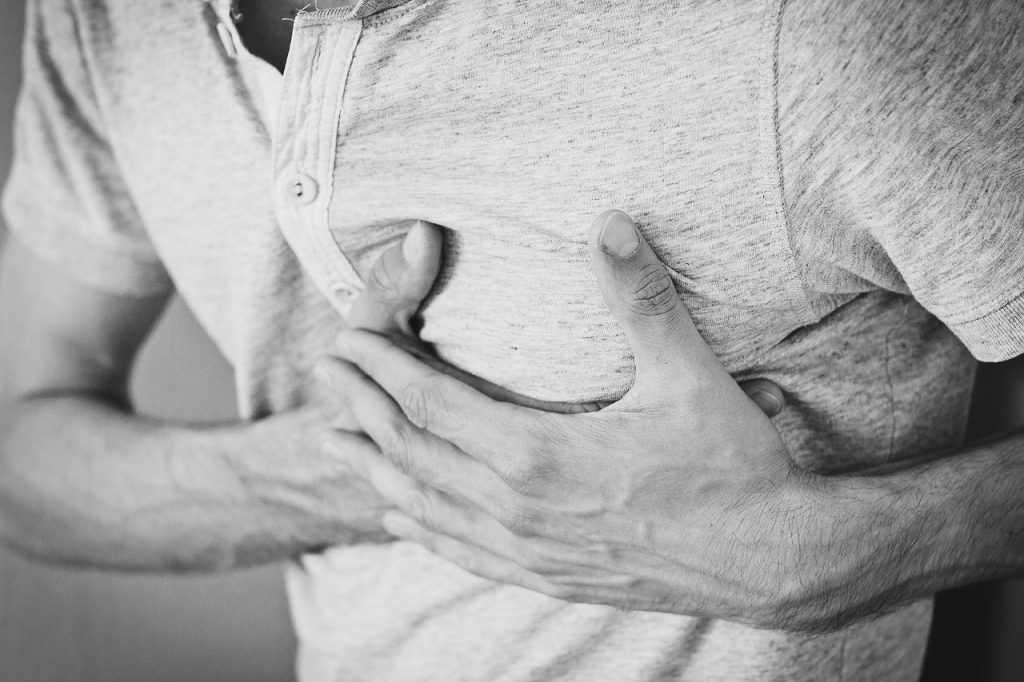 man holds chest in pain