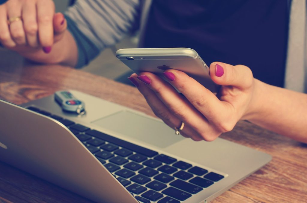 a lady on her phone and laptop