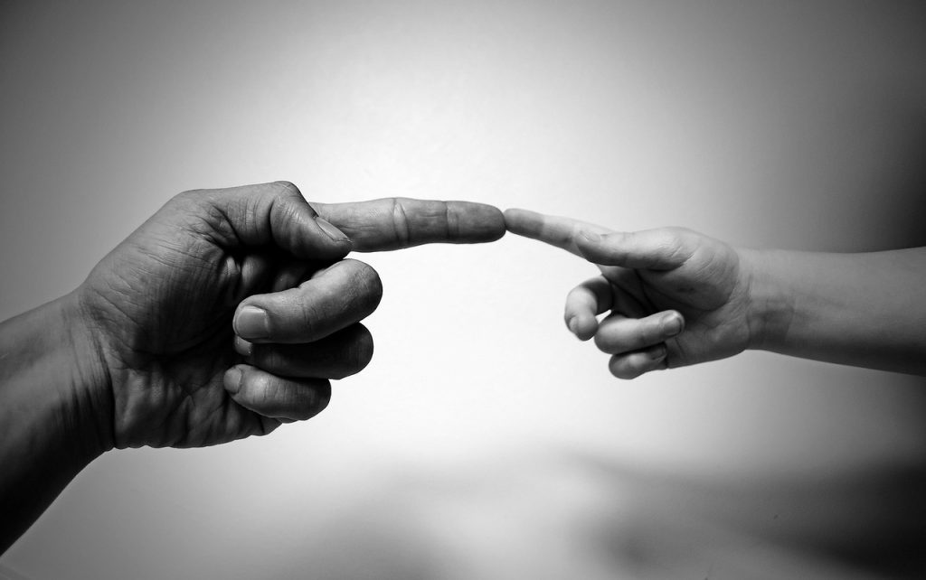 An older gentleman touching fingers with a child, after being treated for eczema causes