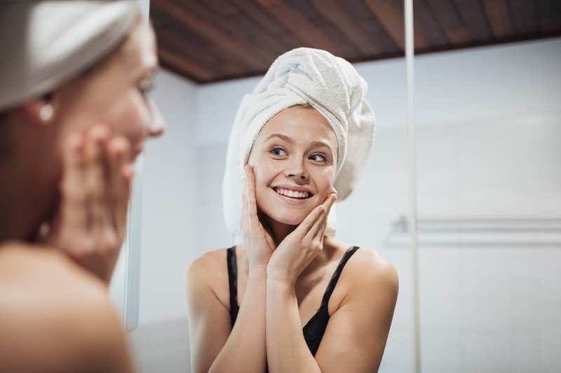 Girl looking in mirror, with towel wrapped on her head